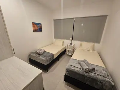a bedroom with two beds and a table with a lamp at Muna Santa Rosa Apartamentos in Tamarindo