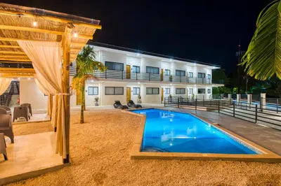 a swimming pool in front of a building at Muna Santa Rosa Apartamentos in Tamarindo