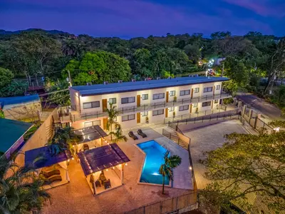 an aerial view of a building with a swimming pool at Muna Santa Rosa Apartamentos in Tamarindo
