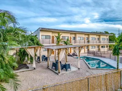 a resort with a pool and a building at Muna Santa Rosa Apartamentos in Tamarindo