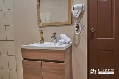 a bathroom with a sink and a mirror at Casa Heliconias La Fortuna Private Pool in Fortuna