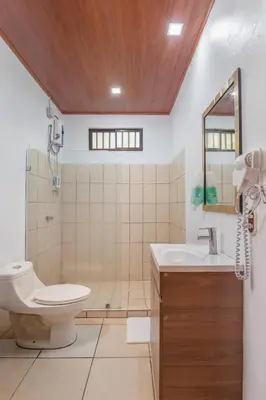 a bathroom with a toilet and a sink at Casa Heliconias La Fortuna Private Pool in Fortuna