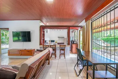 a living room with a table and a dining room at Casa Heliconias La Fortuna Private Pool in Fortuna