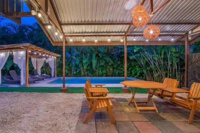 a patio with a table and chairs and a pool at Casa Heliconias La Fortuna Private Pool in Fortuna