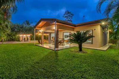 a house with a green lawn in front of it at Casa Heliconias La Fortuna Private Pool in Fortuna