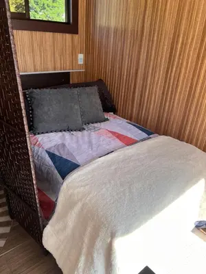 a wicker bed with a blanket and pillows on it at Villazul 2 in Poás