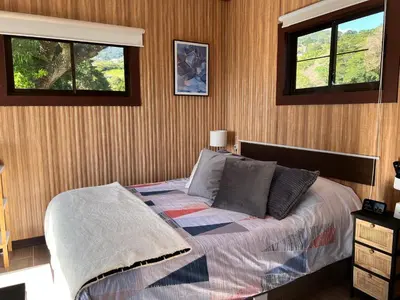 a bedroom with a bed and two windows at Villazul 2 in Poás
