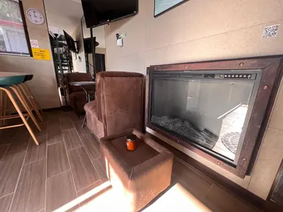 a living room with a large fireplace and a chair at Villazul 2 in Poás