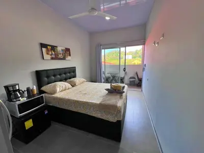 a bedroom with a bed and a large window at CASA MARIPOSA en Punta Leona a 500 metros de la playa FULL EQUIPADA Espacio y precio a tu medida Posibilidad de alquilar la casa entera, dos apartamentos abajo con cocina y jacuzi o 2 cuartos con baños privados en la planta alta Para 1 a 22 personas in Herradura