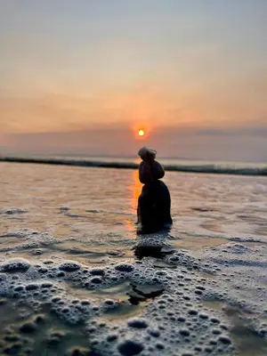 a person sitting in the ocean watching the sunset at CASA MARIPOSA en Punta Leona a 500 metros de la playa FULL EQUIPADA Espacio y precio a tu medida Posibilidad de alquilar la casa entera, dos apartamentos abajo con cocina y jacuzi o 2 cuartos con baños privados en la planta alta Para 1 a 22 personas in Herradura