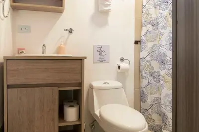 a small bathroom with a toilet and a sink at Emi’s Place Container Living in Uvita