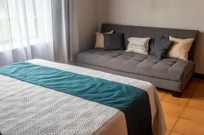 a living room with a couch and a bed at Casa Roble Fortuna in Fortuna