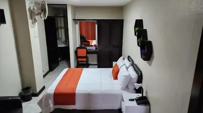 a hotel room with a bed and a desk at Hotel América Heredia in Heredia