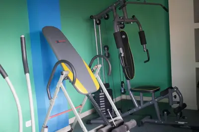 a gym with a treadmill and a chair at Hotel América Heredia in Heredia