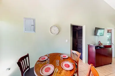 a dining room table with chairs and a clock on a wall at Dolce Vita 7028 in Coco