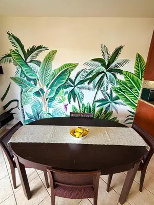 a table with a mural of palm trees on a wall at Breezy Paradise 2 bed2bath with mountain view in Coco