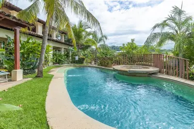 a swimming pool next to a house with palm trees at Breezy Paradise 2 bed2bath with mountain view in Coco