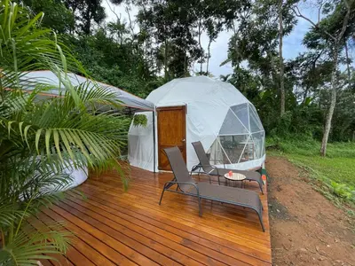 a gazebo with a table and chairs on a wooden deck at La Comarca River Glamping Dome near Manuel Antonio in Manuel Antonio