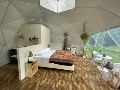 a bedroom in a dome tent with a bed and a table at La Comarca River Glamping Dome near Manuel Antonio in Manuel Antonio