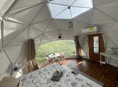 a room with a tent with a bed and a table at La Comarca River Glamping Dome near Manuel Antonio in Manuel Antonio