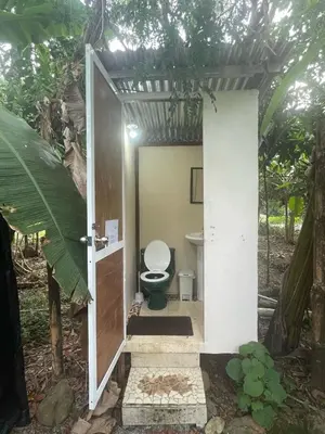 a bathroom with a toilet in a forest at La Comarca River Glamping Dome near Manuel Antonio in Manuel Antonio