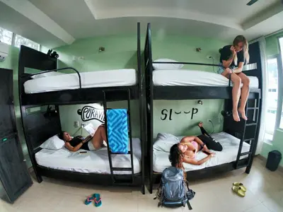 a group of people on bunk beds in a room at Room2Board Hostel and Surf School in Jacó