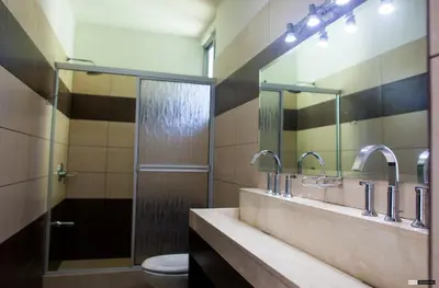 a bathroom with a sink and a shower and a toilet at Room2Board Hostel and Surf School in Jacó