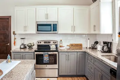 a kitchen with white cabinets and a stove top oven at Casa El Sueño in Brasilito