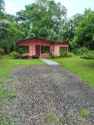 a small red house with a gravel driveway at Paraíso Verde in Siquirres