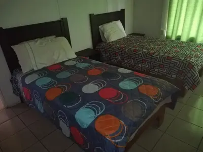 two beds sitting next to each other in a room at Paraíso Verde in Siquirres