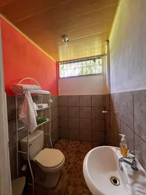 a bathroom with a toilet and a sink at Paraíso Verde in Siquirres