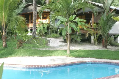 a resort with a swimming pool in front of a house at Hotel Luz de Luna in Santa Teresa Beach