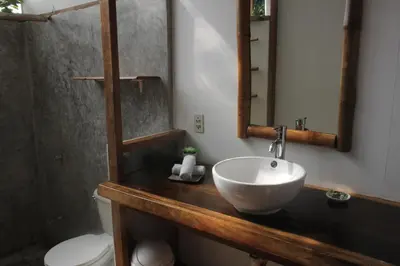 a bathroom with a sink and a mirror and a toilet at Hotel Luz de Luna in Santa Teresa Beach