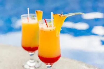 two glasses of orange cocktails sitting on a table at Hotel Arenas en Punta Leona in Jacó