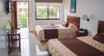 a hotel room with two beds and a window at Hotel Arenas en Punta Leona in Jacó