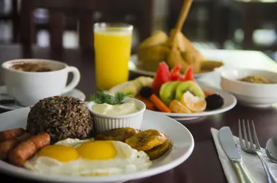 a table topped with plates of breakfast foods and drinks at Hotel Arenas en Punta Leona in Jacó