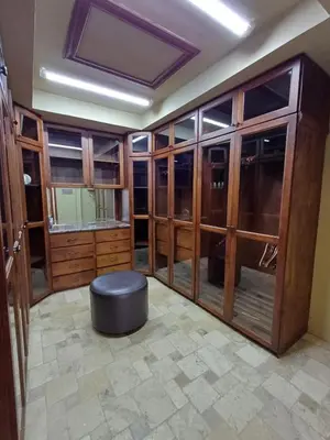 a room with wooden cabinets and a black ottoman at B&B Rosa Dei Venti in Tronadora