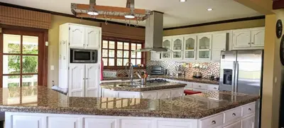 a large kitchen with white cabinets and granite counter tops at B&B Rosa Dei Venti in Tronadora