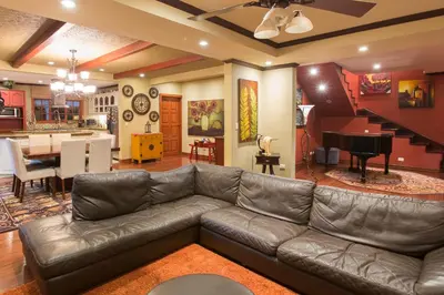 a living room with a leather couch and a kitchen at B&B Rosa Dei Venti in Tronadora