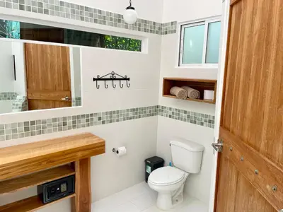 a bathroom with a toilet and a sink at Fuego Lodge in Santa Teresa Beach