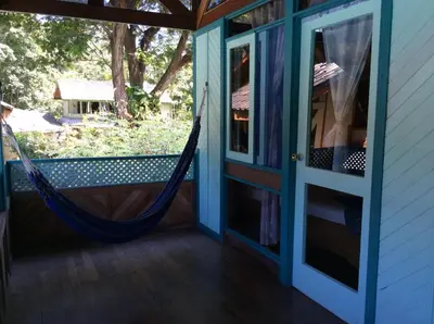 a hammock on the porch of a house at Villas de la Bahia Playa Tambor in Tambor