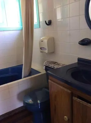 a bathroom with a blue toilet and a sink at Villas de la Bahia Playa Tambor in Tambor