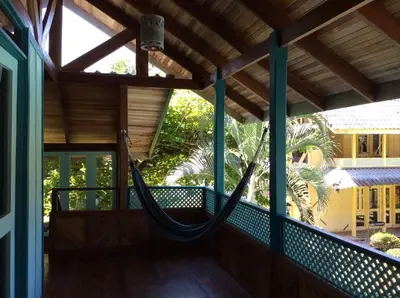a hammock on the front porch of a house at Villas de la Bahia Playa Tambor in Tambor
