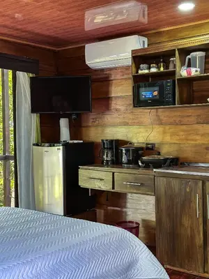 a room with a kitchen with a refrigerator and a microwave at Cabañas Vistas de Altura por Hermanos Solano in San Francisco