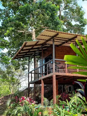 a wooden house with a deck on a hill at Cabañas Vistas de Altura por Hermanos Solano in San Francisco