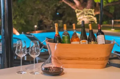 a basket of wine bottles and glasses on a table at Epic Tamarindo Boutique Hotel in Tamarindo