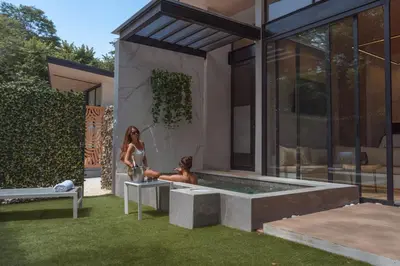 two women sitting in a hot tub outside of a house at Epic Tamarindo Boutique Hotel in Tamarindo