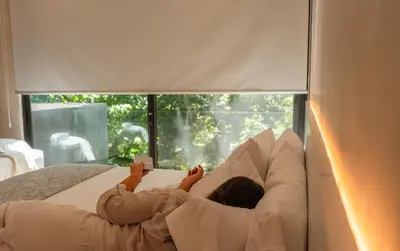 a woman laying on a bed with a book at Epic Tamarindo Boutique Hotel in Tamarindo