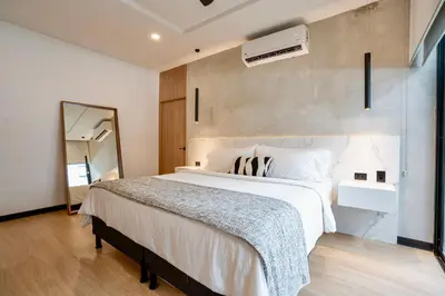 a bedroom with a large white bed and a mirror at Epic Tamarindo Boutique Hotel in Tamarindo