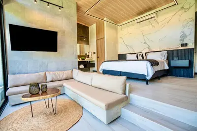 a living room with a couch and a bed at Epic Tamarindo Boutique Hotel in Tamarindo